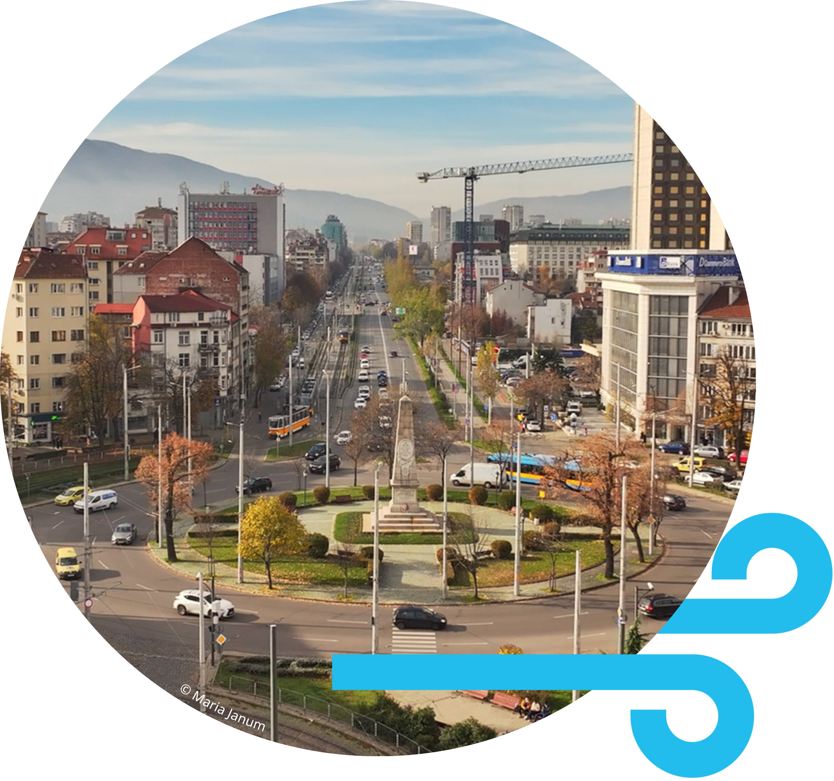 Panoramic view of a street in Sofia, Bulgaria, featuring local urban traffic, historical buildings, and mountains in the background.