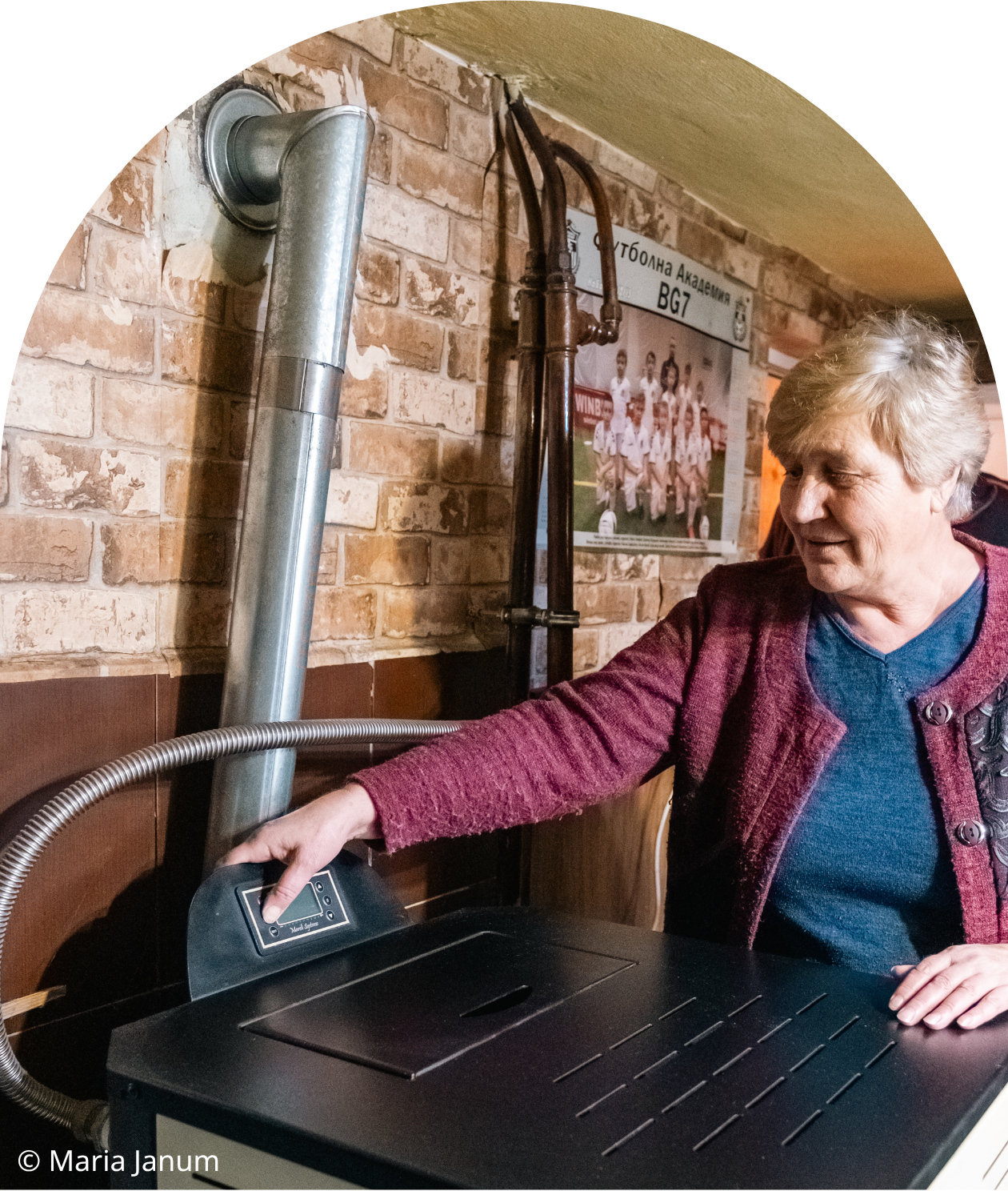 An elderly woman standing in her home next to a modern, clean heating system replacement in Sofia, Bulgaria.